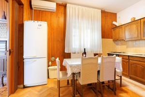 y cocina con mesa, sillas y nevera. en Apartments with a parking space Sumpetar, Omis - 950, en Sumpetar