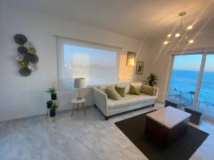 a living room with a couch and a large window at Lovely 2 bedroom oceanfront condo in Mazatlan in Mazatlán