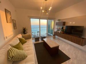 a living room with a white couch and a television at Lovely 2 bedroom oceanfront condo in Mazatlan in Mazatlán
