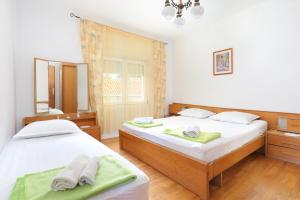ein Schlafzimmer mit 2 Betten und Handtüchern darauf in der Unterkunft Apartments by the sea Orij, Omis - 7534 in Dugi Rat