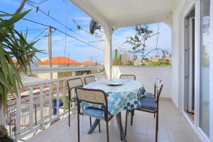 stół i krzesła na balkonie z widokiem w obiekcie Apartments by the sea Orij, Omis - 7534 w mieście Dugi Rat
