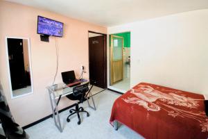 a bedroom with a bed and a desk and a television at Cómoda habitación doble 5 min del Aeropuerto CDMX in Mexico City