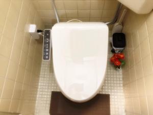 a white toilet in a bathroom with red flowers at Nishikujo stay5 - Vacation STAY 14800 in Osaka