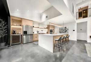 a large kitchen with a counter and stools at 1_OAK - experience custom design - 2 masters in Houston