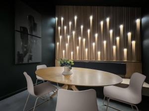 a dining room with a table and chairs and lights at 1_OAK - experience custom design - 2 masters in Houston