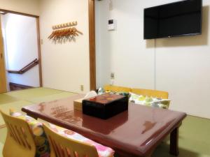 jadalnia ze stołem, krzesłami i telewizorem w obiekcie Nishikujo stay5 - Vacation STAY 14800 w Osace