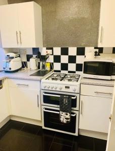 a kitchen with a stove and a microwave at Cosy Room by Excel, Emirates Cable Car, 02Arena in London