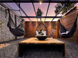 a patio with two hanging hammocks and a table at 1_OAK - experience custom design - 2 masters in Houston