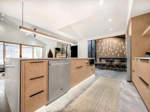 a kitchen with wooden cabinets and a dining room at 1_OAK - experience custom design - 2 masters in Houston