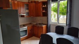 a kitchen with wooden cabinets and a table and a window at Apartments by the sea Postira, Brac - 9241 in Postira