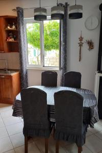 a dining room table with chairs and a window at Apartments by the sea Postira, Brac - 9241 in Postira +15 photos