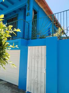 a blue house with white doors and a fence at Monchita's Ensenada Baja, apartments for rent. in Ensenada