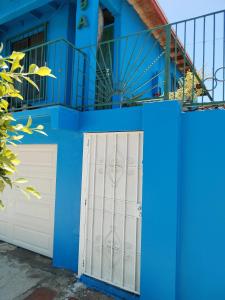 a blue house with a white garage door at Monchita's Ensenada Baja, apartments for rent. in Ensenada