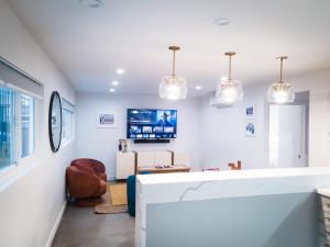 a white living room with a tv on the wall at The Redline Venice in Los Angeles
