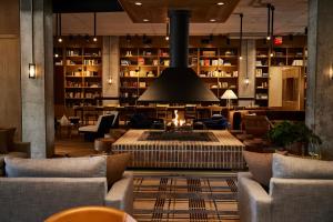 a lobby with a fireplace and couches and a library at The Junto in Columbus