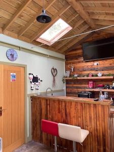 a kitchen with a bar with a cow on the wall at Maple tree lodge. Quirky handcrafted Irish cabin in Dromara