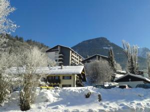 ein Gebäude im Schnee mit Bergen im Hintergrund in der Unterkunft Haus Mitterbach Ferienwohnung Bergliebe in Berchtesgaden