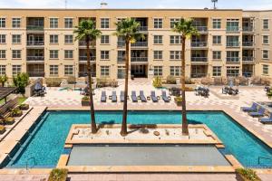 un immeuble d'appartements avec piscine et palmiers dans l'établissement The Olivia: Riverwalk Loft, à San Antonio