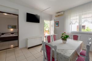 a dining room with a table and a bedroom at Apartments with a parking space Tar, Porec - 6948 in Tar
