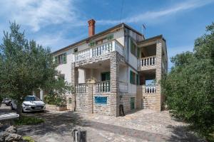 a large brick building with a car parked in front of it at Triple Room Mrljane 327a in Neviđane