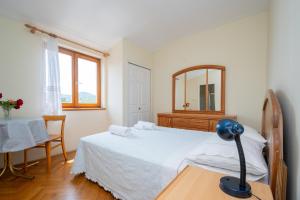 a bedroom with a bed and a mirror and a table at Triple Room Mrljane 327a in Neviđane