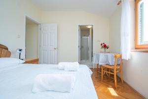 ein Schlafzimmer mit 2 Betten und einem Tisch mit Blumen darauf in der Unterkunft Triple Room Mrljane 327a in Neviđane