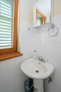 a white bathroom with a sink and a mirror at Triple Room Mrljane 327a in Neviđane
