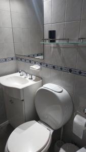 a bathroom with a white toilet and a sink at Dpto Belgrano Bea in Buenos Aires