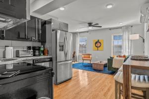 a kitchen with stainless steel appliances and a living room at Stay Rafa At 259 in Philadelphia