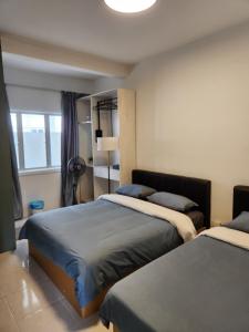 a bedroom with two beds and a window at The Art Gallery Emerald Avenue Cameron Highlands 10Pax 828 Wifi in Brinchang