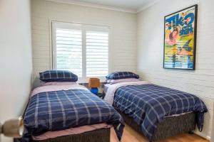 two twin beds in a room with a window at Modern Boutique CBD 2BR 1st Floor Apt in Canberra