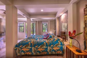 a bedroom with a bed with a blue comforter at Gardenia Room on Tropical Lush Farm in Haiku, Maui in Huelo