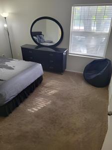 a bedroom with a bed and a mirror and a chair at Serenity Apartment in Chesterfield