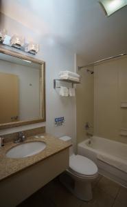 a bathroom with a sink and a toilet and a tub at Sky Hotel Flushing/Laguardia Airport in Queens