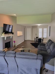 a living room with couches and a flat screen tv at Serenity Apartment in Chesterfield