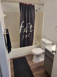 a bathroom with a toilet and a shower curtain at Serenity Apartment in Chesterfield