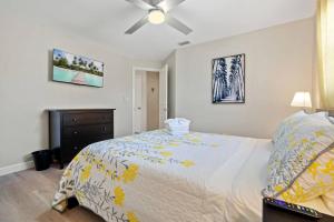 a bedroom with a bed and a ceiling fan at Boaters Bayshore Bungalow in Naples
