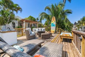 a deck with chairs and a surfboard on a house at Boaters Bayshore Bungalow in Naples