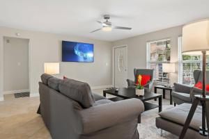 a living room with a couch and two chairs at Boaters Bayshore Bungalow in Naples