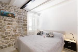 ein Schlafzimmer mit einem Bett und einer Steinwand in der Unterkunft Apartment Stone in Split