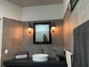 uma casa de banho com um lavatório e um espelho em Good Life Lodge em Sámara