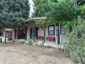 una piccola casa con una panchina rossa sul portico di Long Shot Cabin a Red River