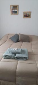 Una cama con dos toallas encima. en Casa/ Villa General Belgrano en Villa General Belgrano
