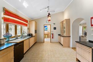 a large kitchen with wooden cabinets and a tile floor at The Quinta Bio Pool, Swimming Pool, 3 Bedroom ensuites Villa in Almancil