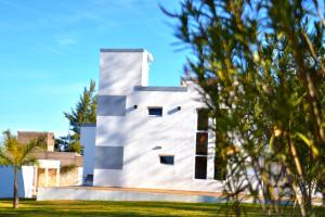 a white house with black windows and trees at La Soñada in Chilecito