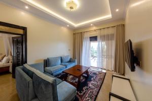 a living room with a blue couch and a table at Las Vegas Garden Hotel Mbarara in Mbarara