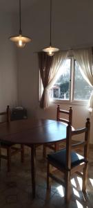 comedor con mesa, sillas y ventana en Casa/ Villa General Belgrano en Villa General Belgrano