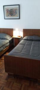 1 dormitorio con 2 camas y mesa con lámpara en Casa/ Villa General Belgrano en Villa General Belgrano