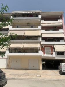 un edificio blanco alto con un estacionamiento en Gerard Luxury apartment, en Patra