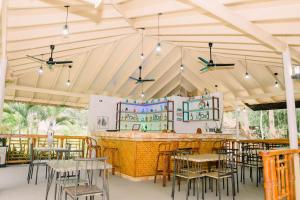 um restaurante com mesas e cadeiras e um bar em Denika's Suites em Puerto Princesa